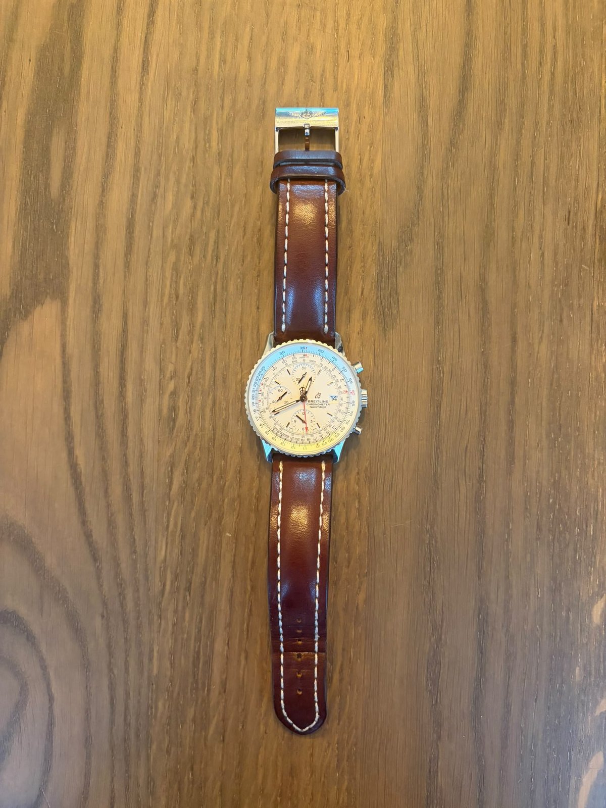 Breitling Navitimer Chronograph 41 — full watch with cream dial and brown leather strap, shown on a wooden surface